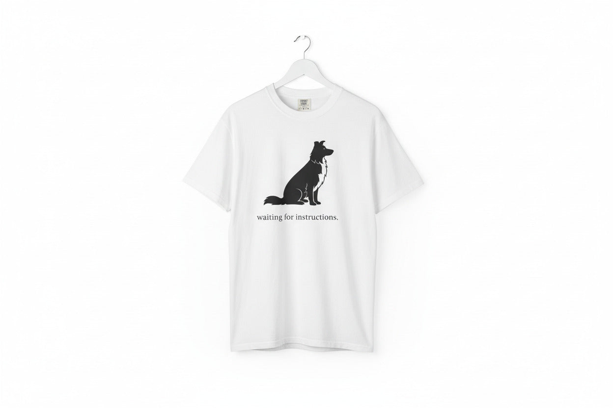 White t-shirt with a black dog graphic and text 'waiting for instructions' on a white background- put on a hanger